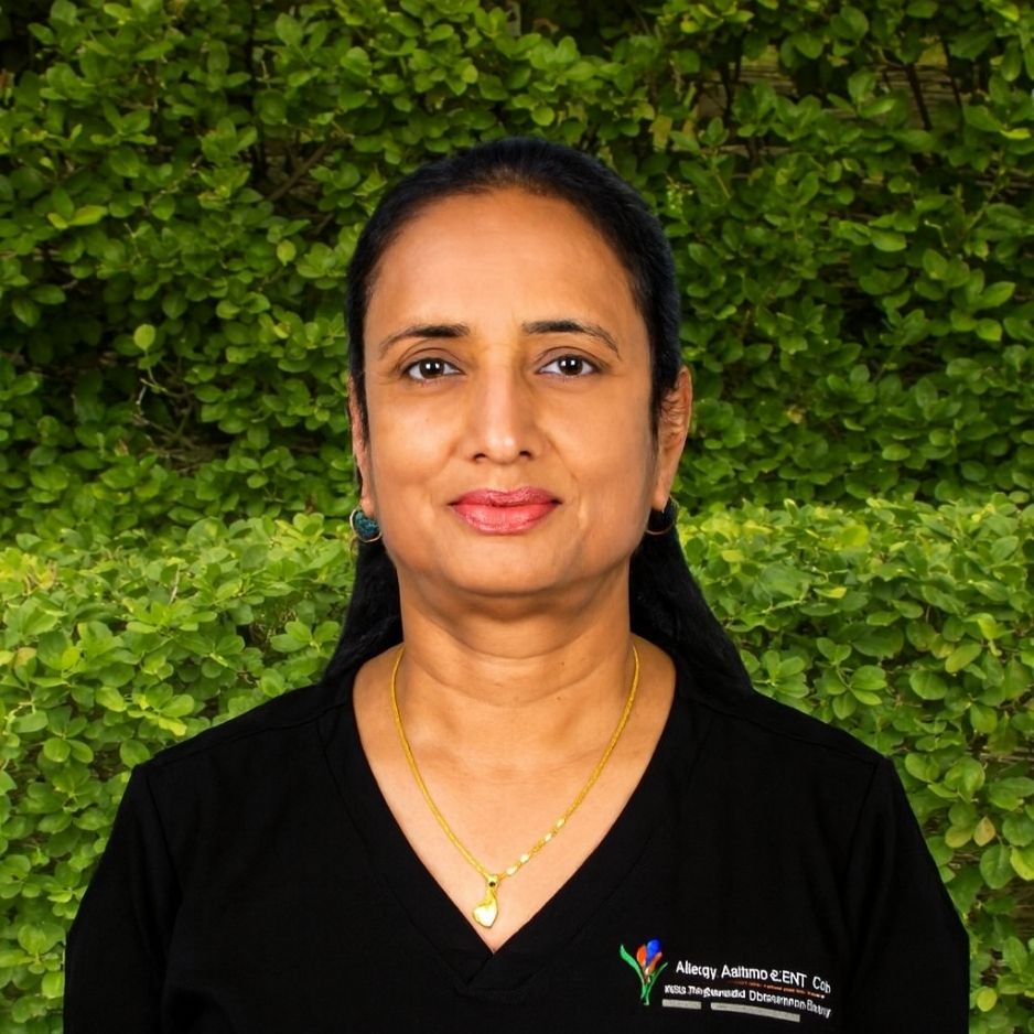 A team member in a black AAIC scrub top stands outdoors among green foliage, reflecting dedication to research within the clinic.